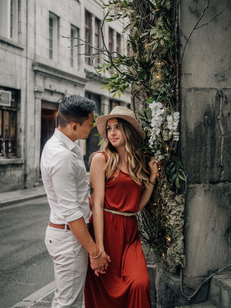 Couple dans la rue près de fleurs lors d'un shooting photo couple lifestyle