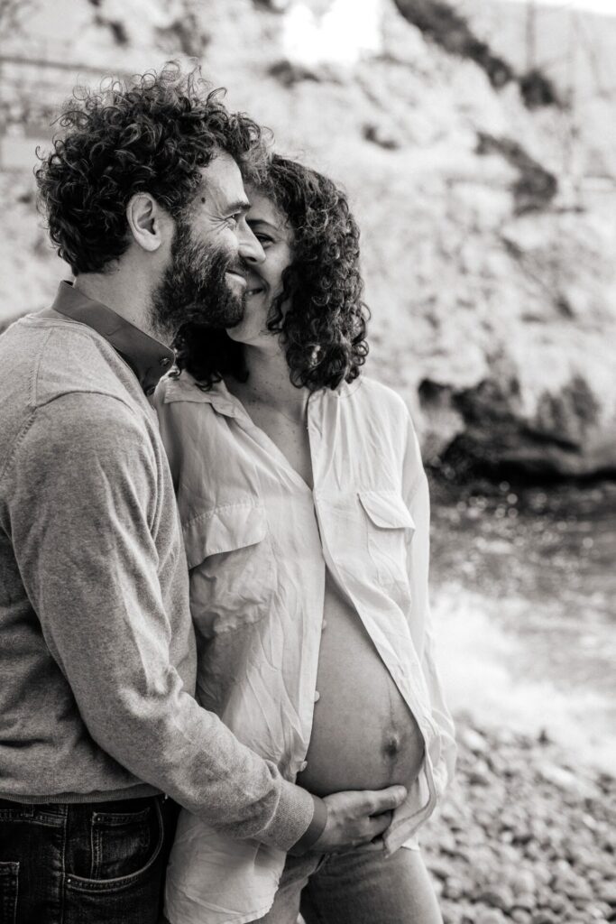 couple souriant lors d'une séance photo grossesse naturelle en extérieur