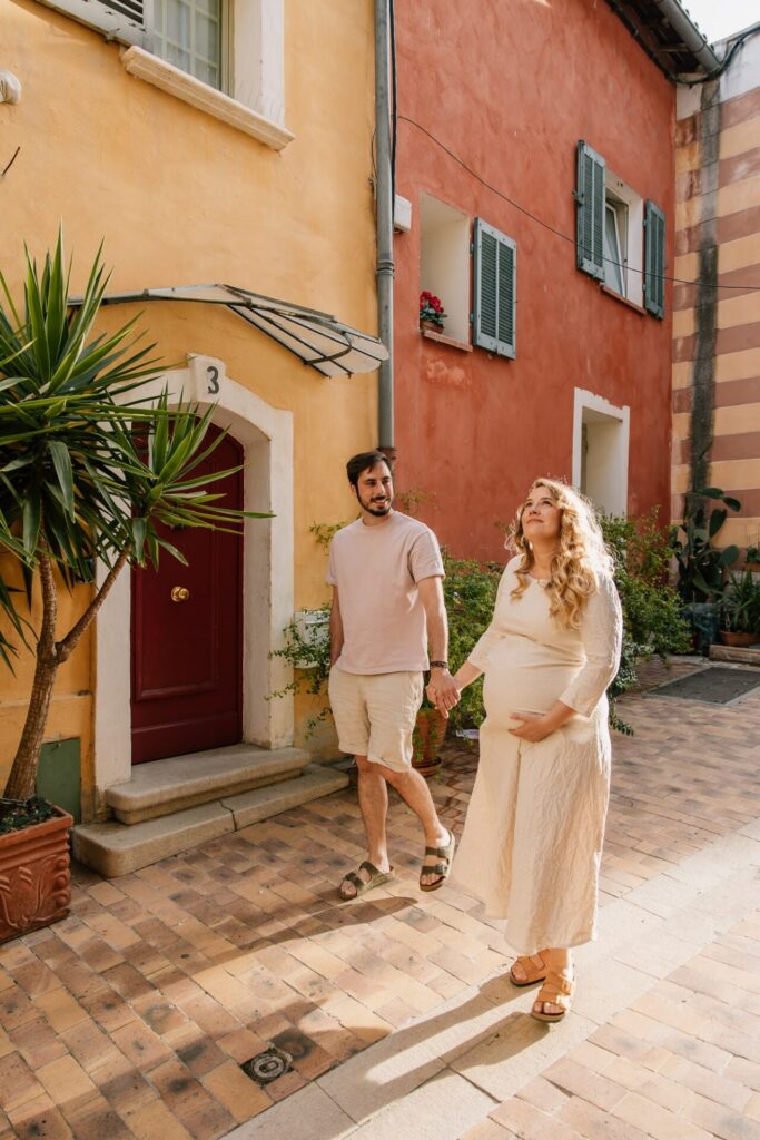 couple marchant dans une ruelle colorée pendant une séance photo grossesse