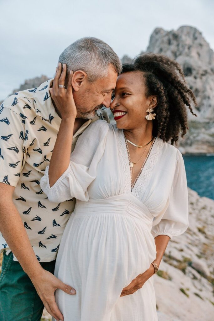 couple attendant un bébé lors d'une séance photo grossesse en bord de mer