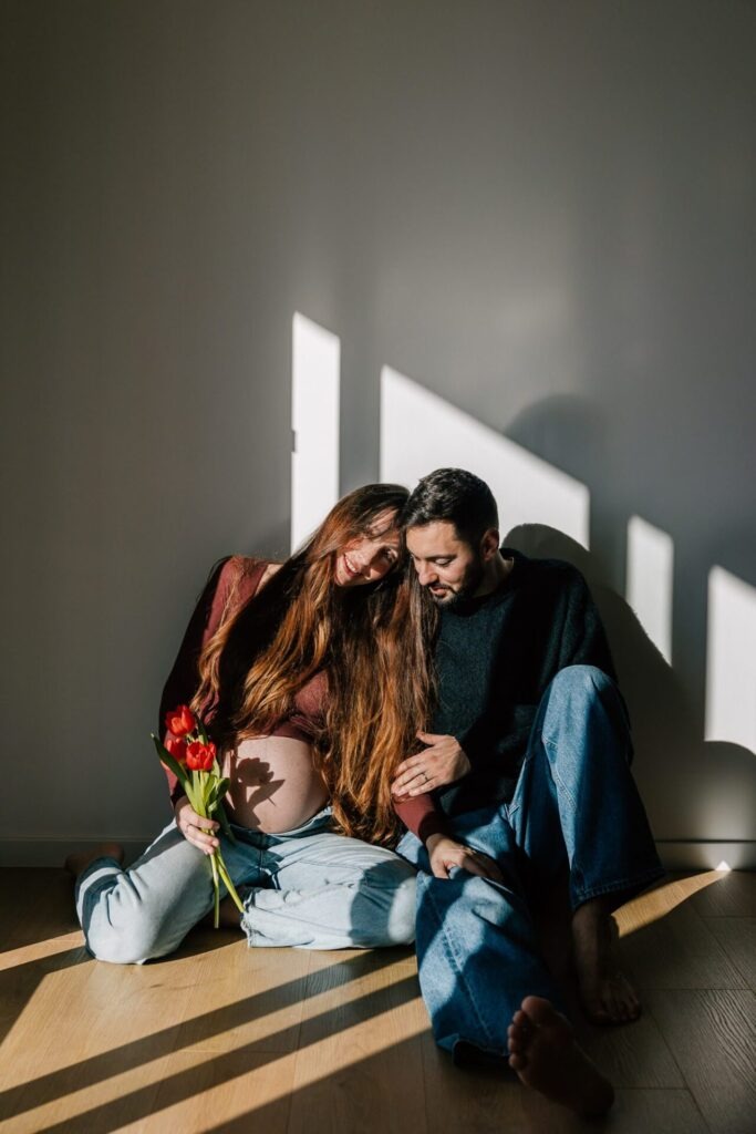 séance photo grossesse à domicile à Aix-en-Provence avec lumière naturelle et couple assis au sol