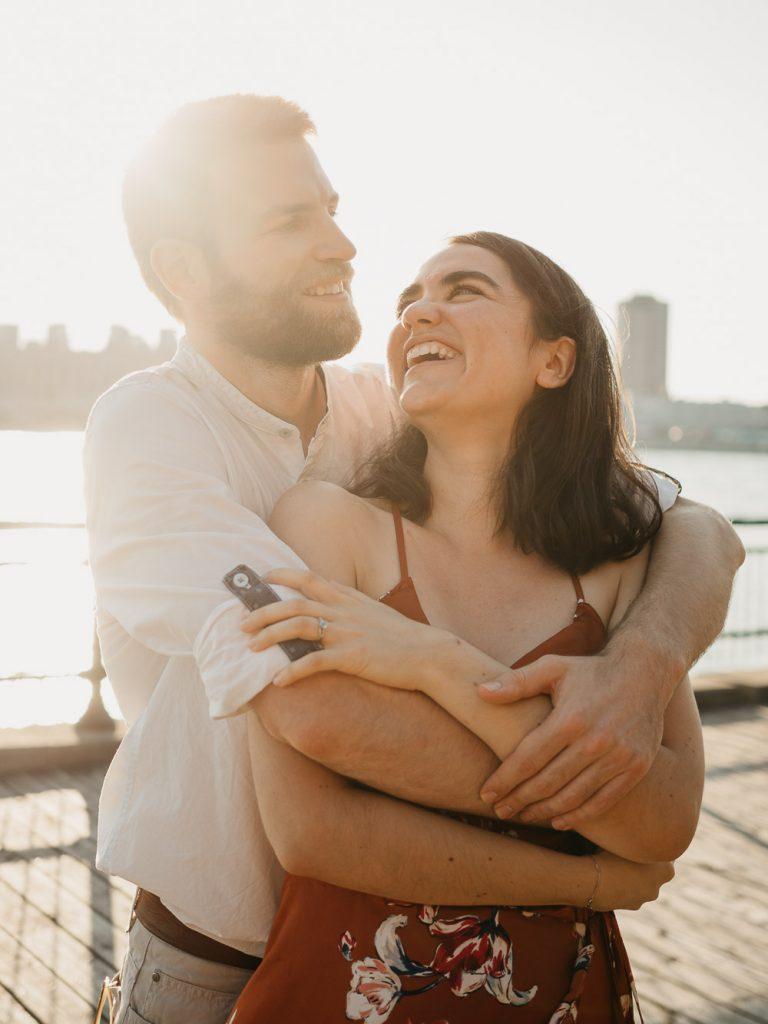 Couple d'amoureux qui s'enlace face au fleuve au coucher de soleil lors d'une séance photo de couple à Marseille