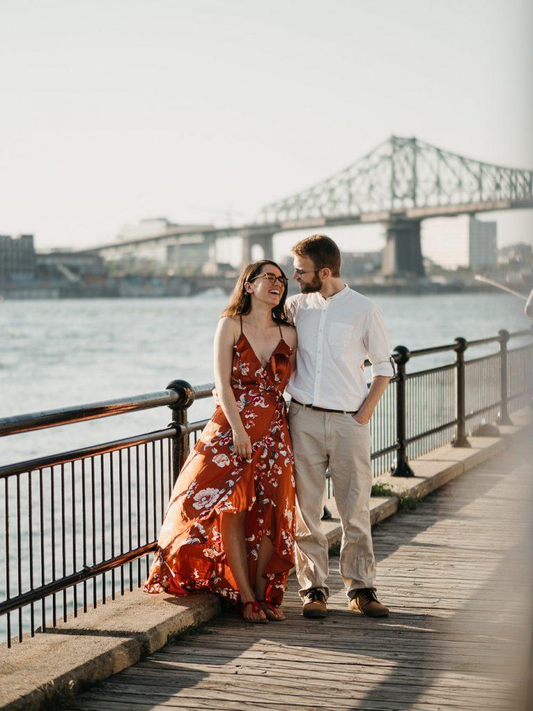 portrait d'un couple d'amoureux qui marche sur les quais au coucher de soleil lors d'un shooting photo de couple