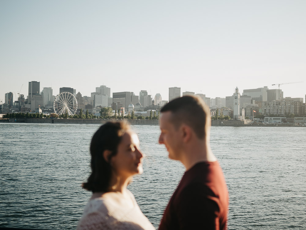 couple d'amoureux qui se regardent pendant une séance photo couple lifestyle, en arrière-plan la skyline de la ville à l'horizon