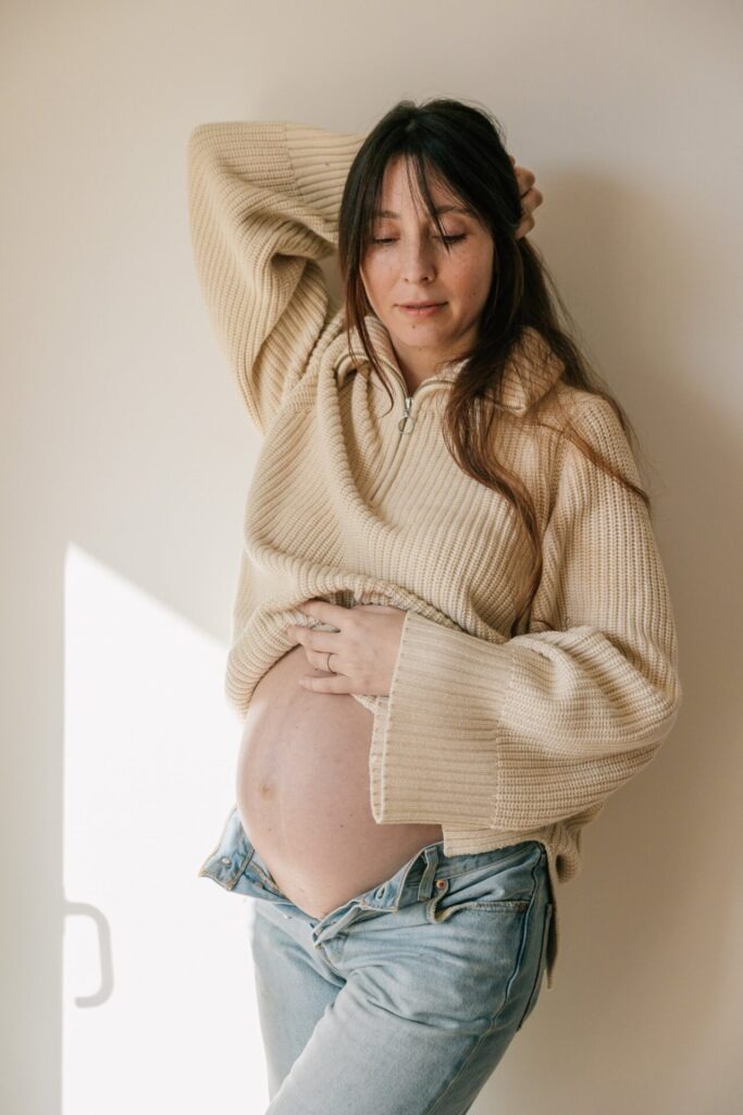 portrait de femme enceinte près d’une fenêtre lors d’une séance photo grossesse à domicile à Marseille