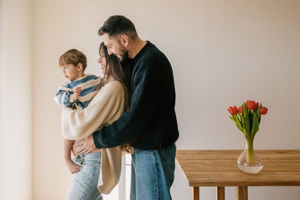 Parents serrant leur enfant dans les bras lors d'une séance photo de famille à domicile à Aix-en-Provence