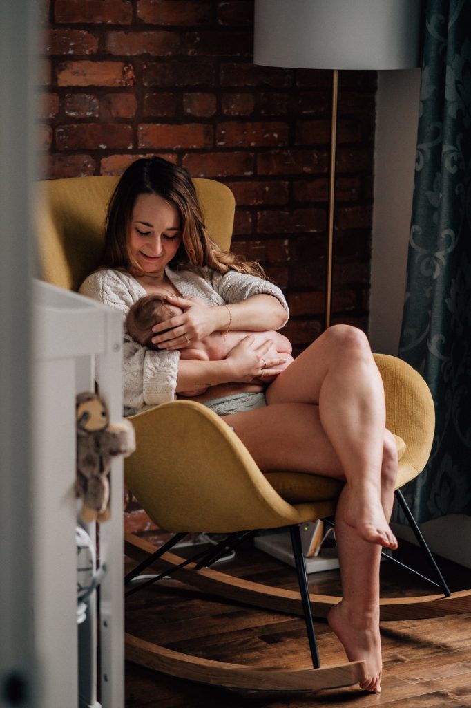 magnifique connexion pendant l'allaitement entre une maman et son bébé nus lors d'une séance photo intime peau à peau à la maison
