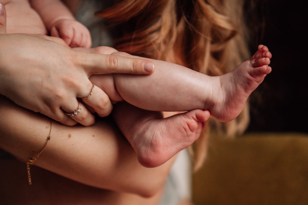 image de pied de bébé dans les bras de sa maman pour le portfolio d'une photographe de famille et de séance photo de nouveau-né