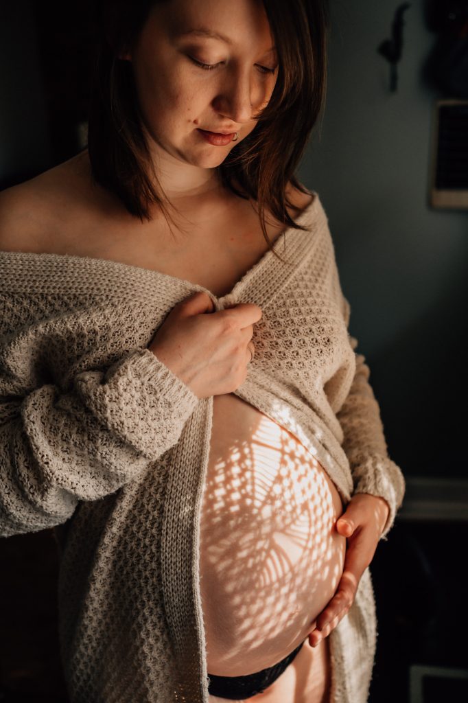 magnifique motif de lumière sur le ventre d'une femme enceinte lors d'une séance photo de grossesse à Marseille