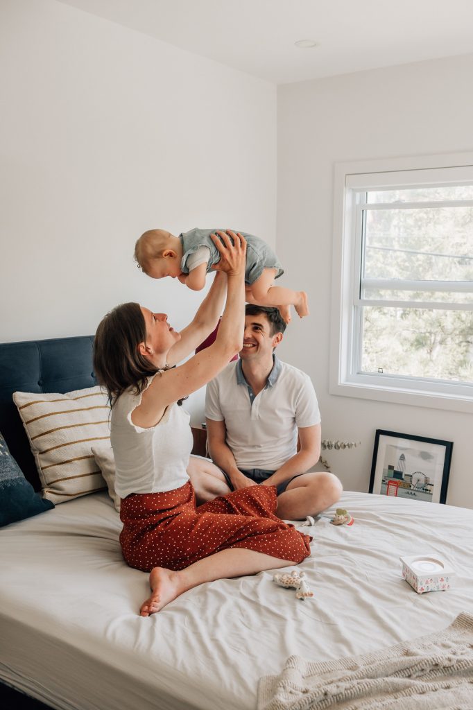 portfolio de séance photo de famille à domicile à Marseille : maman et papa qui jouent avec bébé sur le lit familial