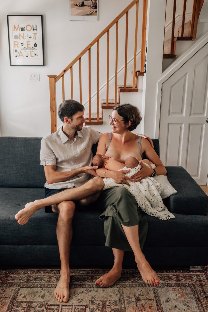 maman allaite ses jumeaux nouveau-nés avec papa à ses côtés lors d'un shooting photo bébé à la maison à Marseille