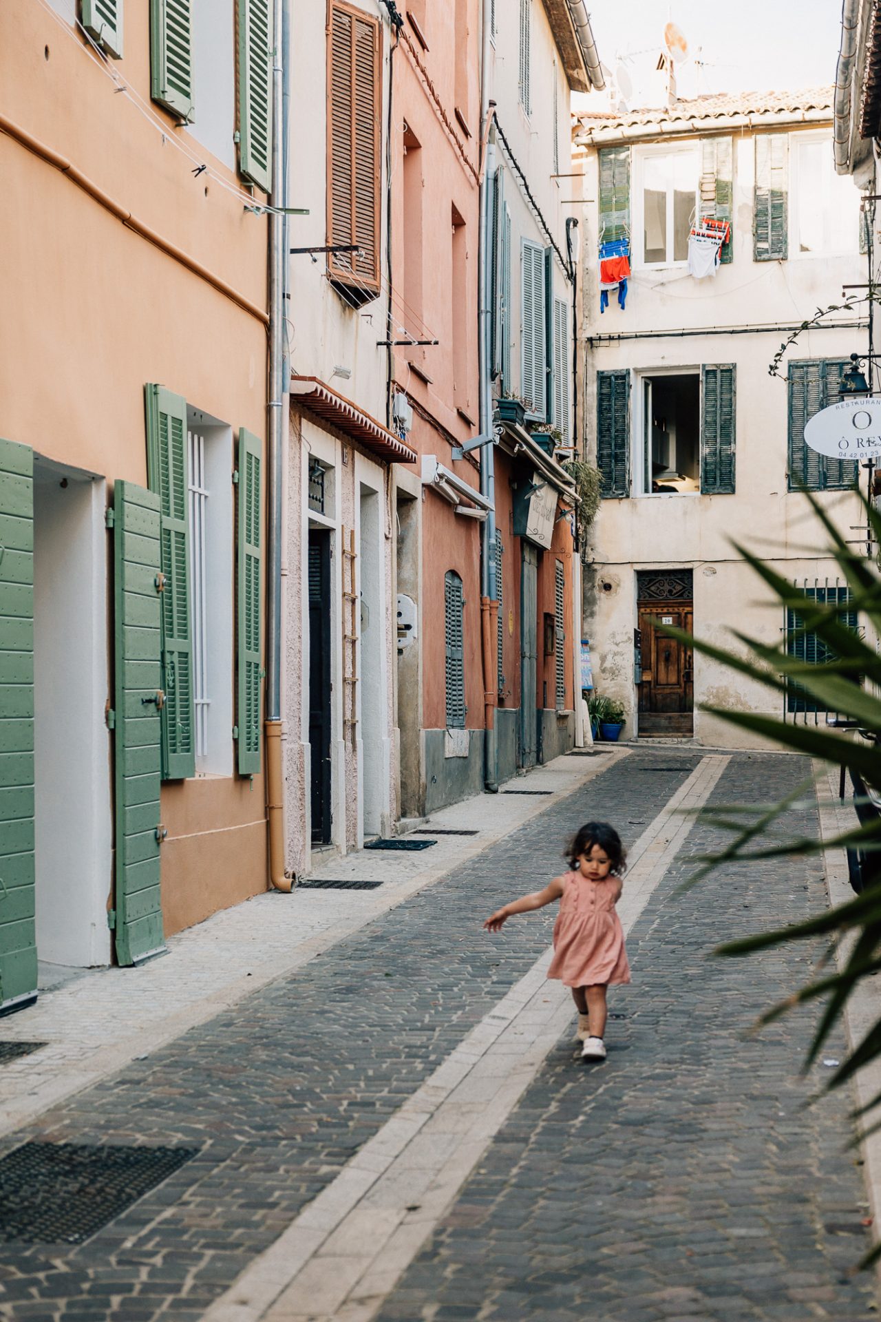 petite fille marche dans les rues colorées de Cassis pendant une séance photo à Marseille