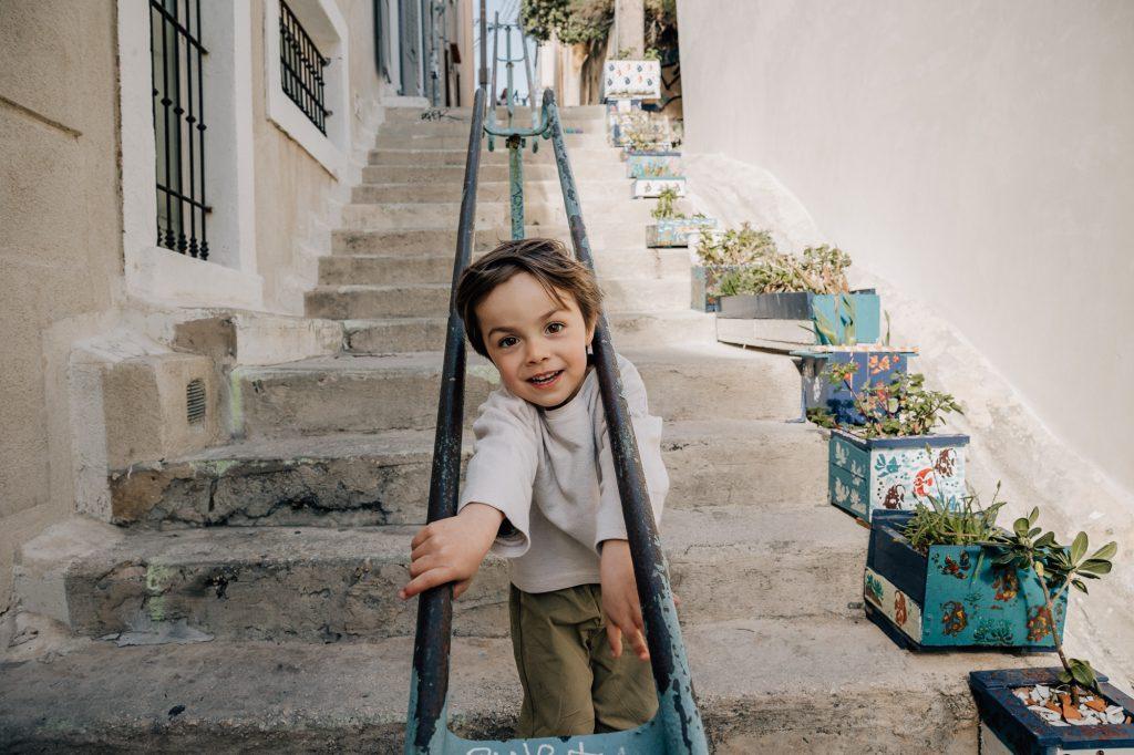 petit garçon jouant dans les escaliers de Malmousque lors d'une séance photo famille à Marseille