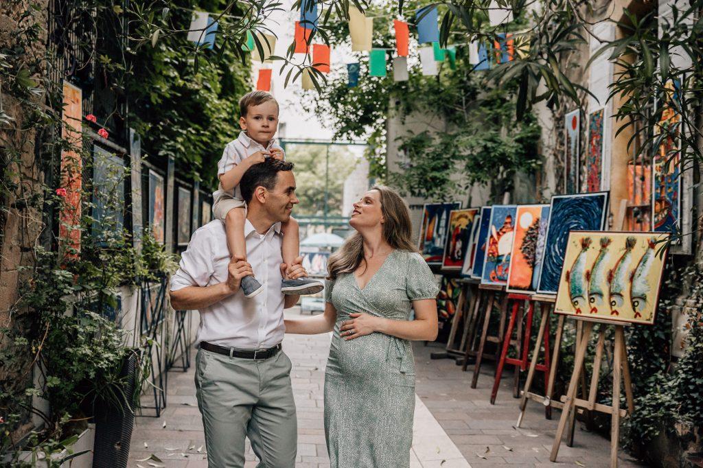 portrait de famille heureuse avec une femme enceinte dans les ruelles du Panier pendant un shooting photo grossesse à Marseille