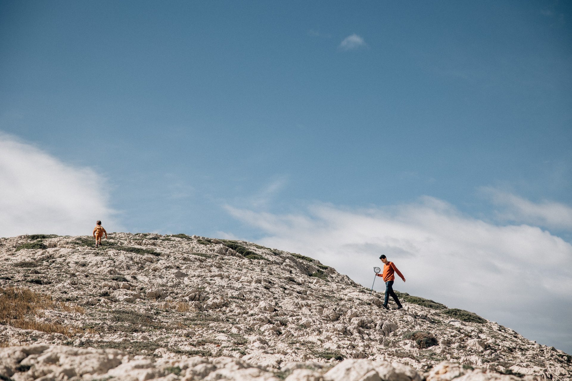 papa se promène avec son fils dans les calanques à Marseille pendant une séance photo famille à Marseille