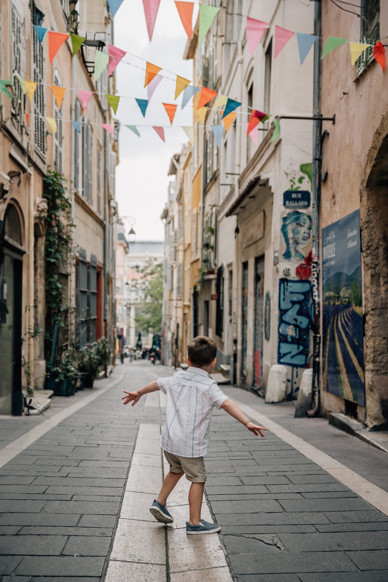 a little guy in the street of Le Panier during a vacation family photoshoot in Marseille, France