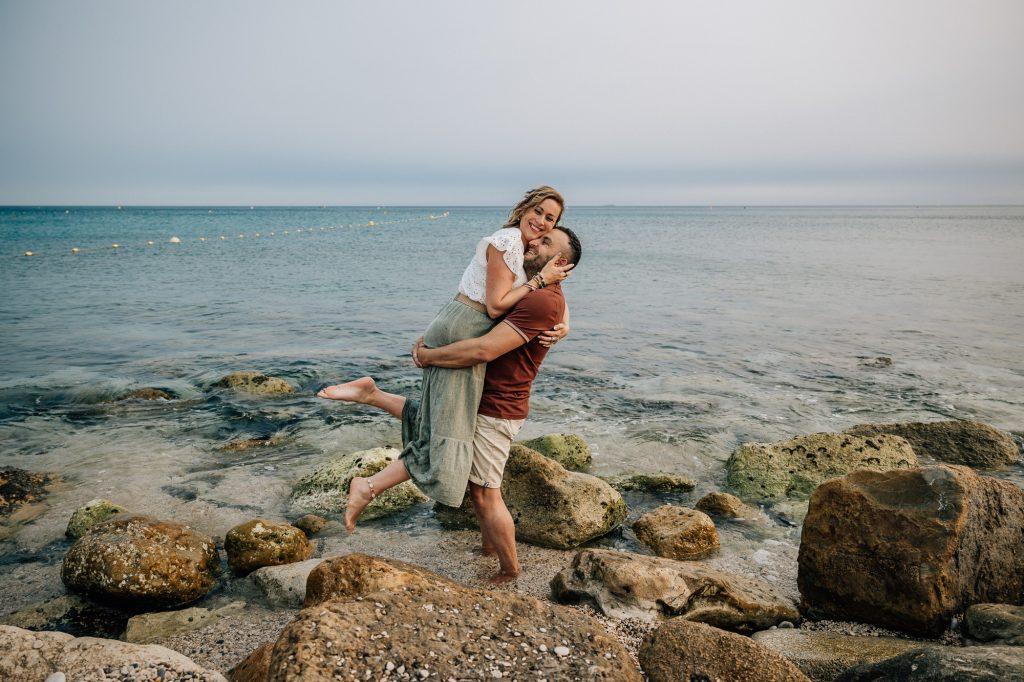 un couple heureux s'amuse au bord de l'eau lors d'un shooting photo de couple à Cassis