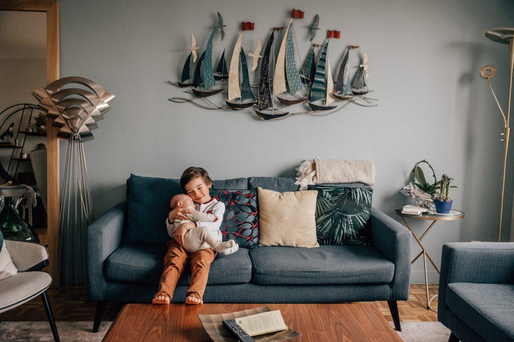 tendre portrait d'un enfant avec son nouveau frère lors d'une séance photo famille à domicile à Marseille