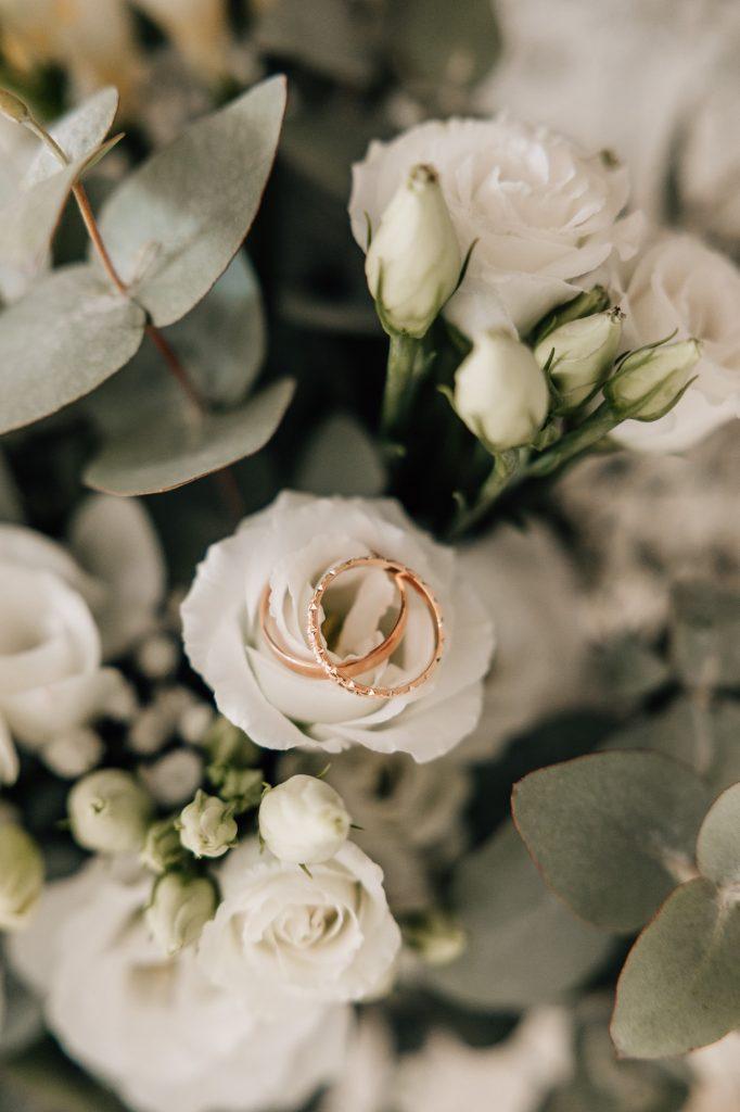 Alliances dans le bouquet de fleurs blanches de la mariée