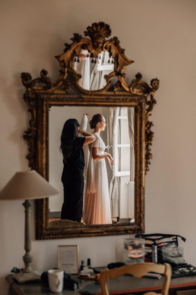 reflet dans un miroir de la mariée qui met son voile lors des préparatifs de son mariage en Provence