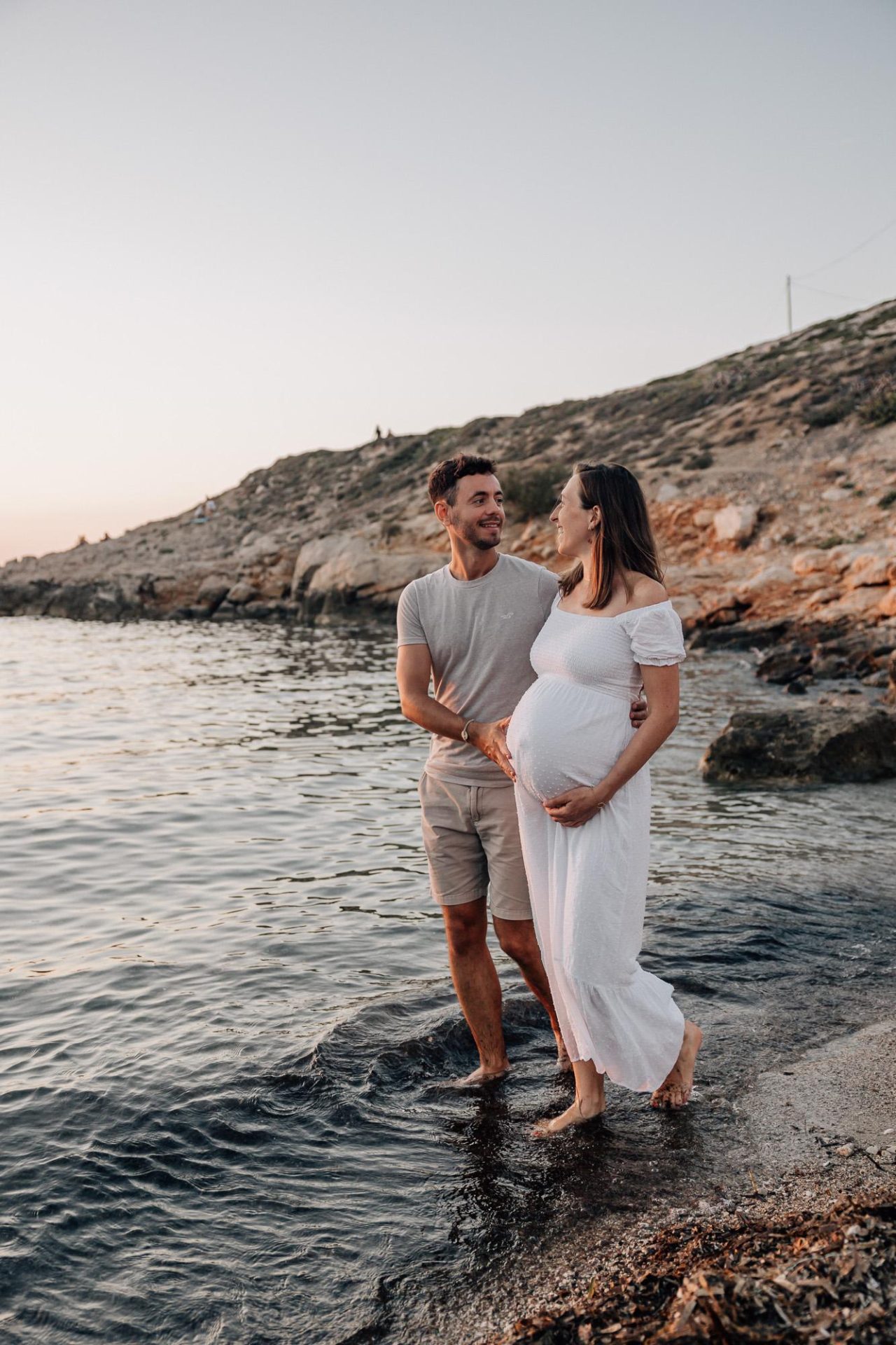 couple marchant lors d'un shooting photo de grossesse dans l'eau des Calanques à Marseille