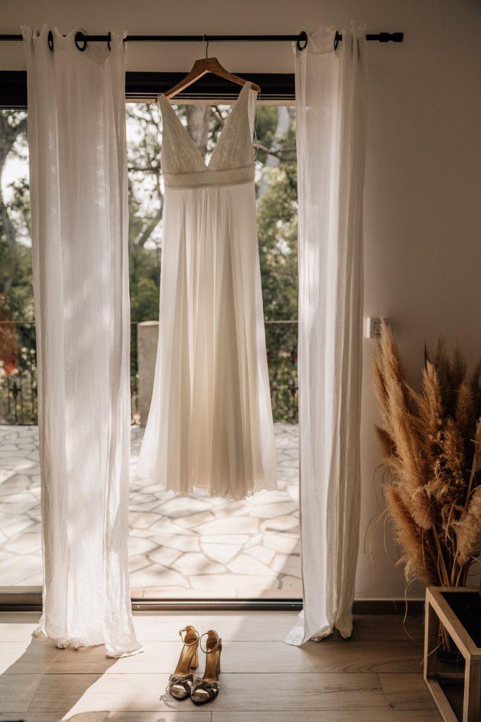 Robe de mariée suspendue à la fenêtre lors des préparatifs de mariage à Aix-en-Provence