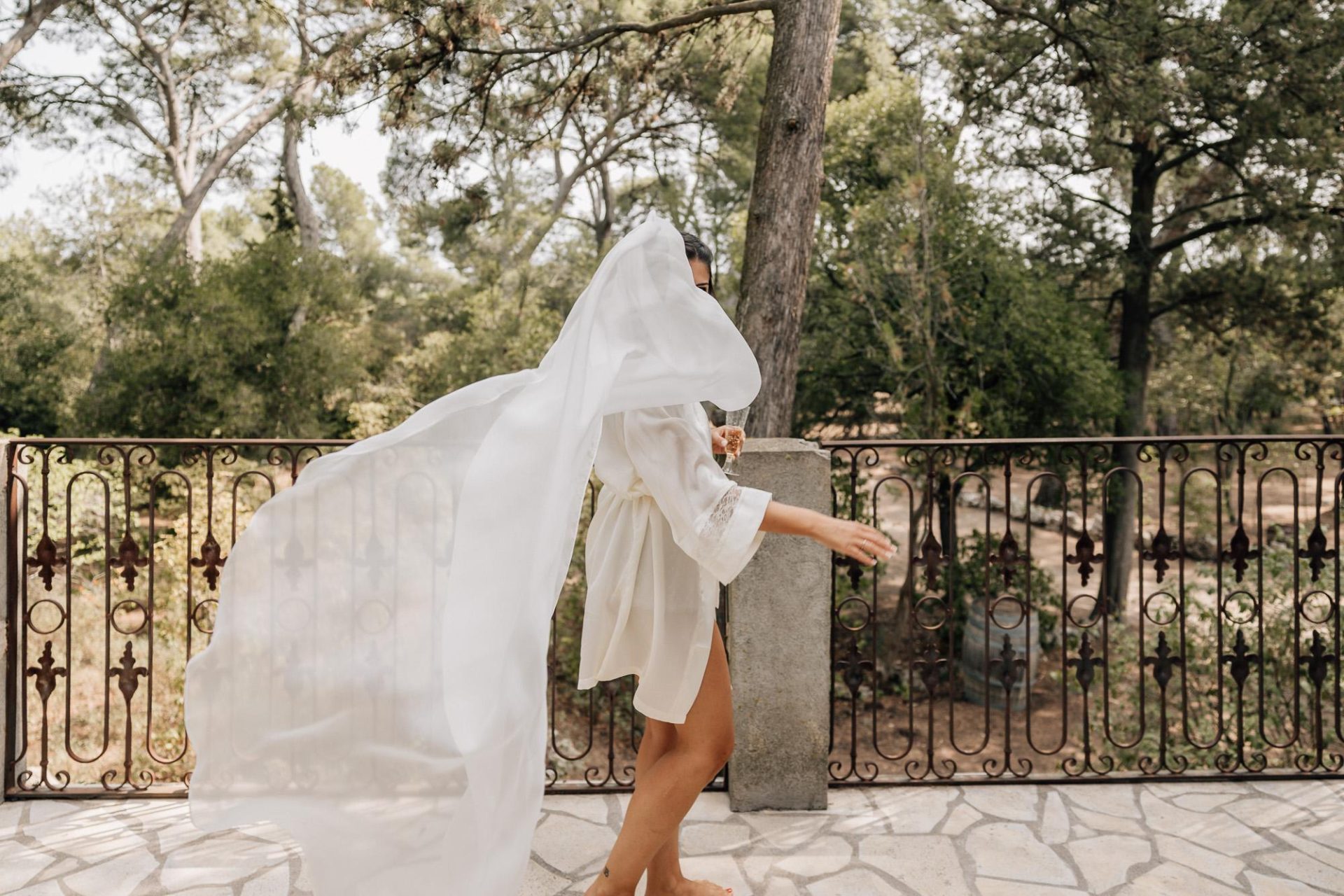 La mariée joue avec son voile lors des préparatifs du mariage en Provence