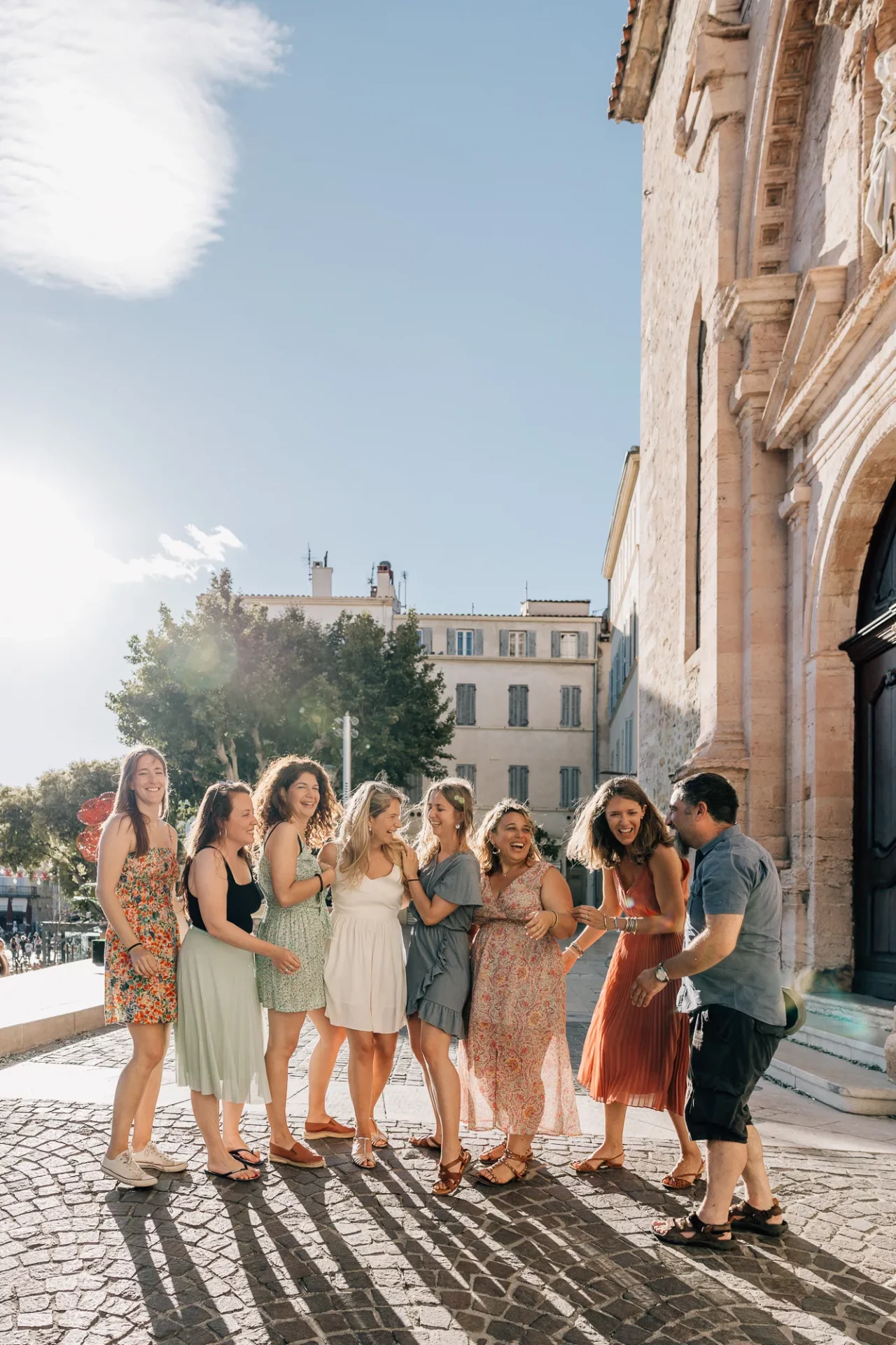 groupe d'amies en robe fleuries s'amuse lors d'une promenade pour un shooting photo enterrement de vie de jeune fille à la Ciotat