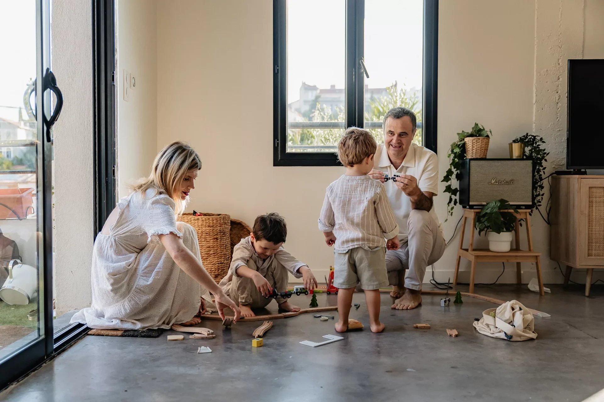 Enfants et parents jouent au petit train lors d'un shooting photo lifestyle de famille à domicile dans Marseille 13007