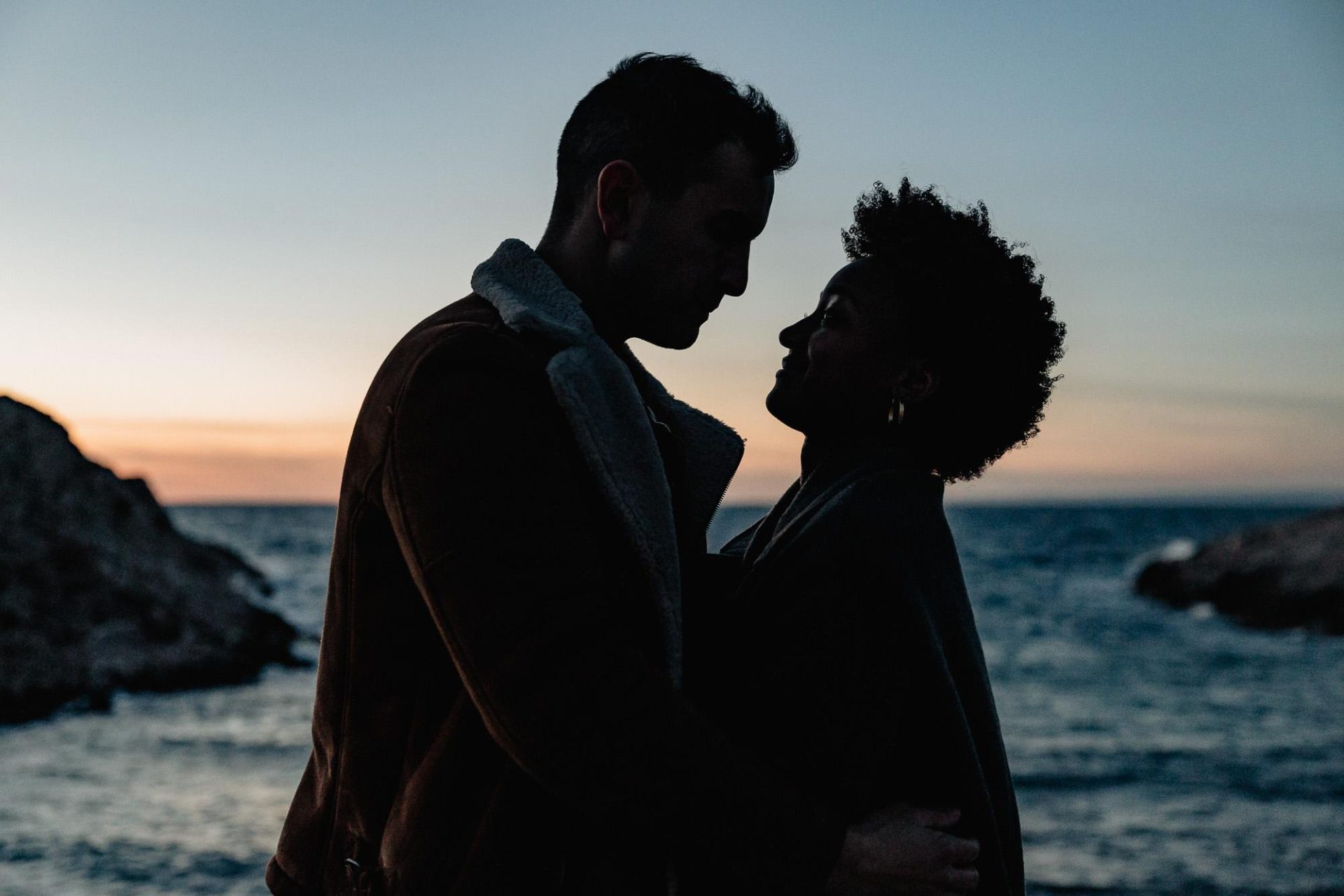 silhouette d'un couple qui se regarde pendant un coucher de soleil à la plage de Marseille lors d'un shooting photo