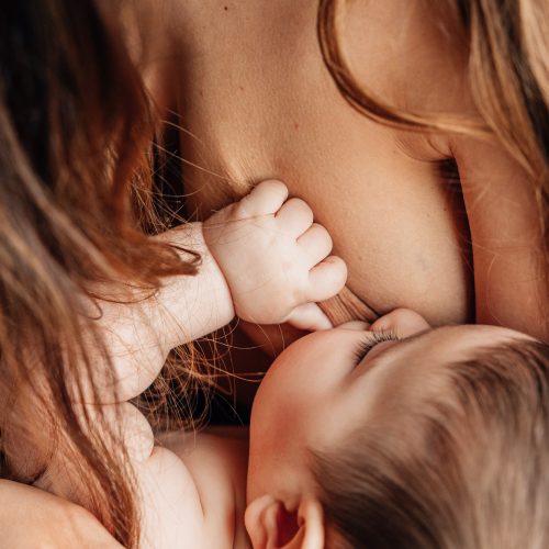 maman allaite son bébé en peau à peau lors d'une séance photo nouveau-né à domicile avec une photographe à Marseille