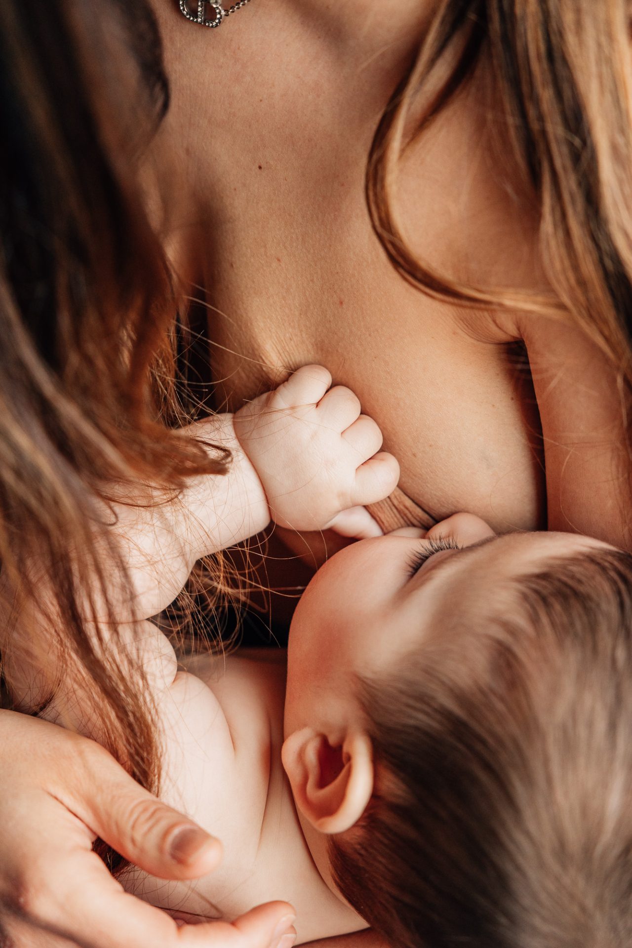 maman allaite son bébé en peau à peau lors d'une séance photo nouveau-né à domicile avec une photographe à Marseille