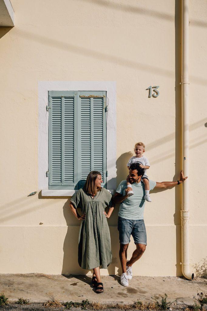 parents posent devant une maison colorée dans les rues de Malmousque lors d'un shooting photo à Marseille