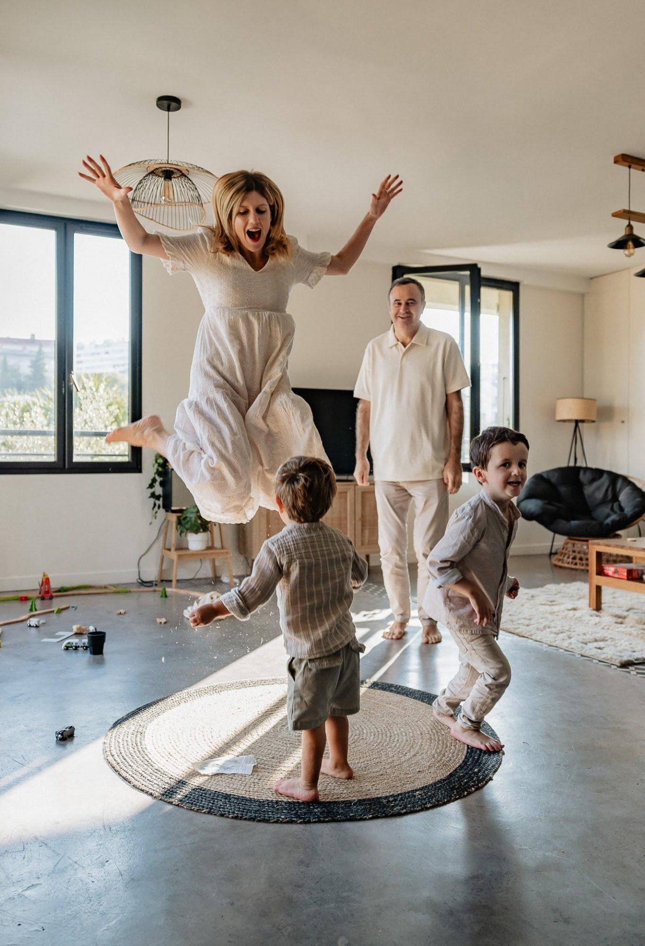 Enfants et parents dansent dans le salon lors d'un shooting photo lifestyle de famille à domicile dans Marseille 13007