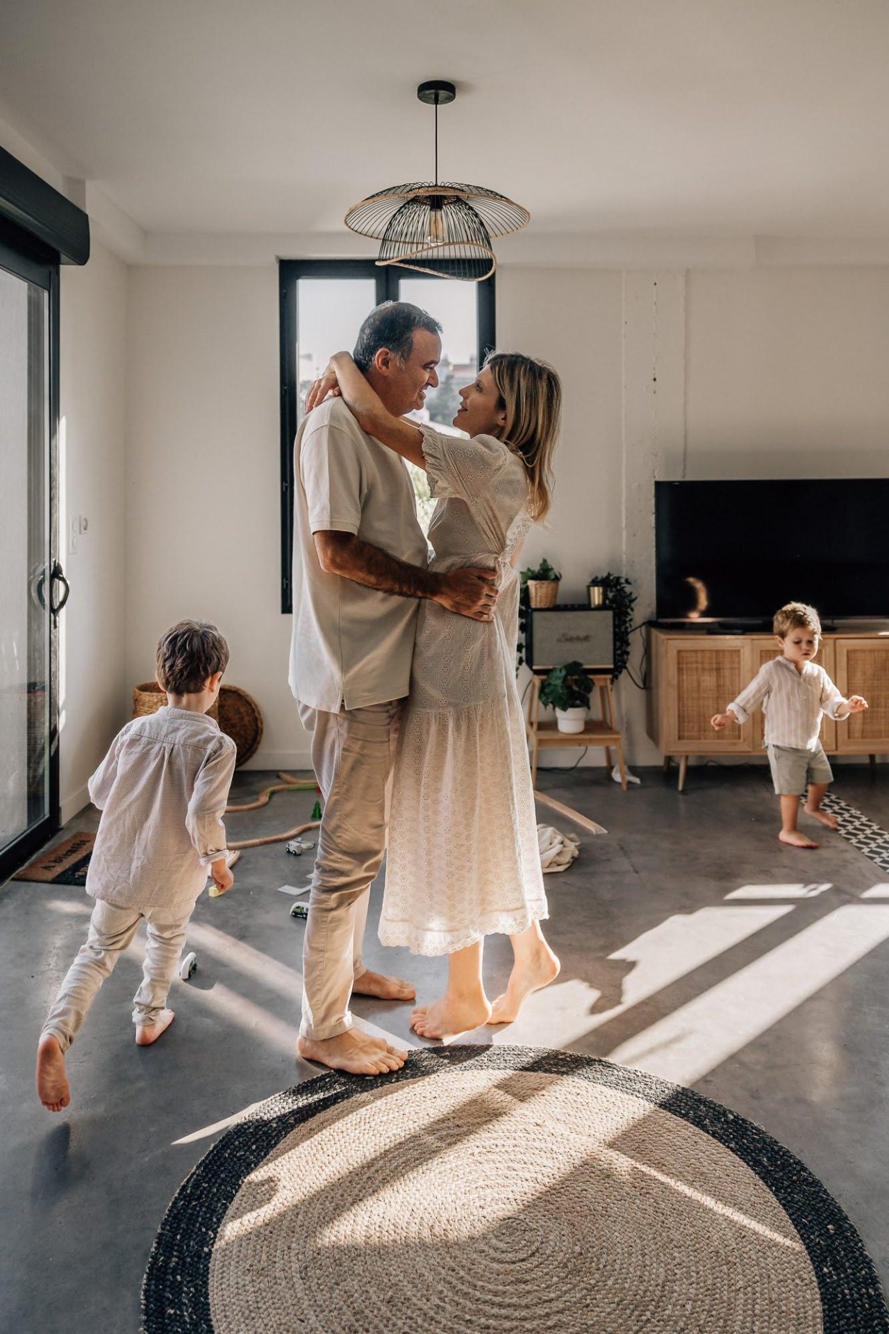 Enfants et parents dansent dans le salon lors d'un shooting photo lifestyle de famille à domicile dans Marseille 13007
