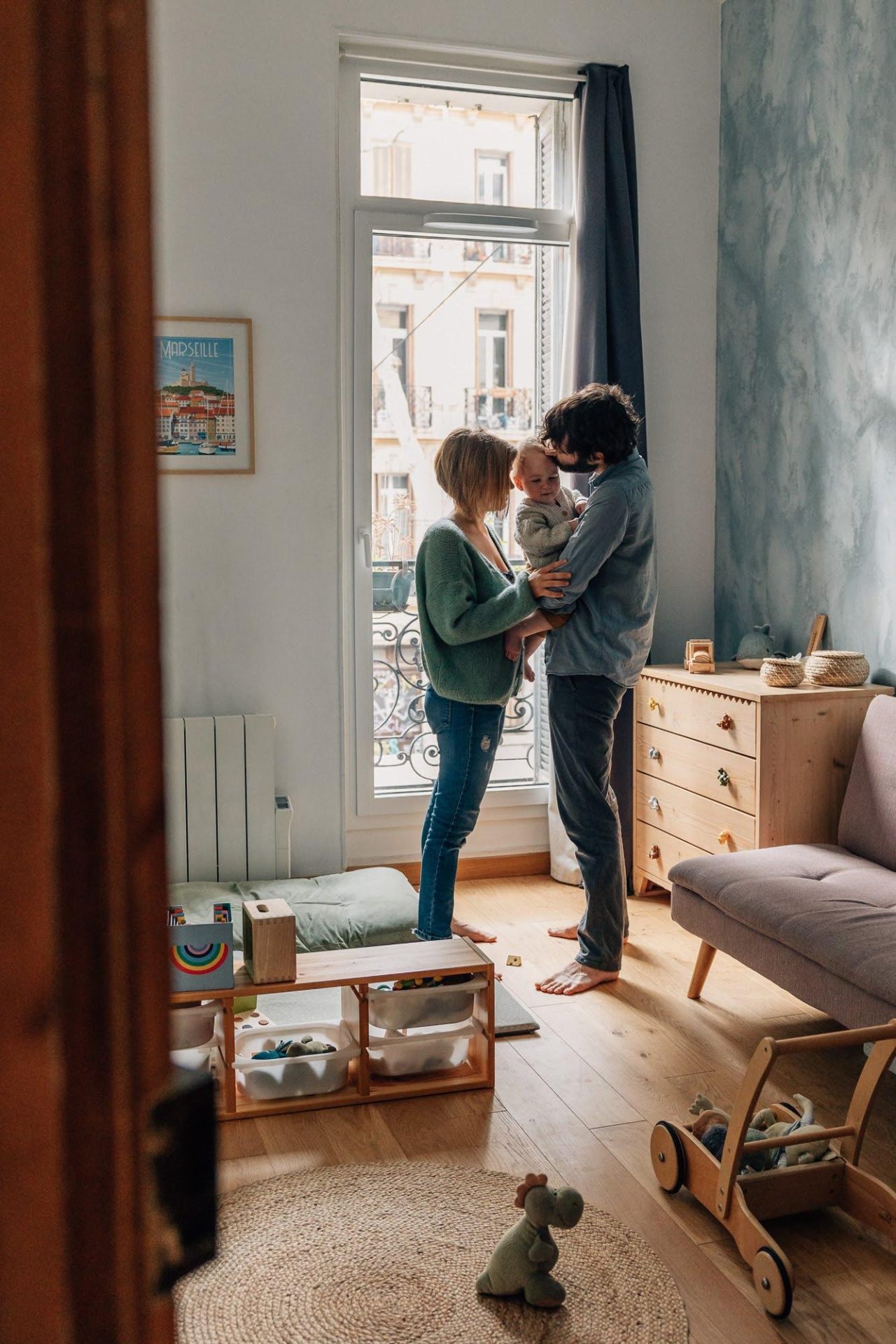 famille posant dans la chambre de bébé lors d'un shooting photo à domicile dans Marseille 13005