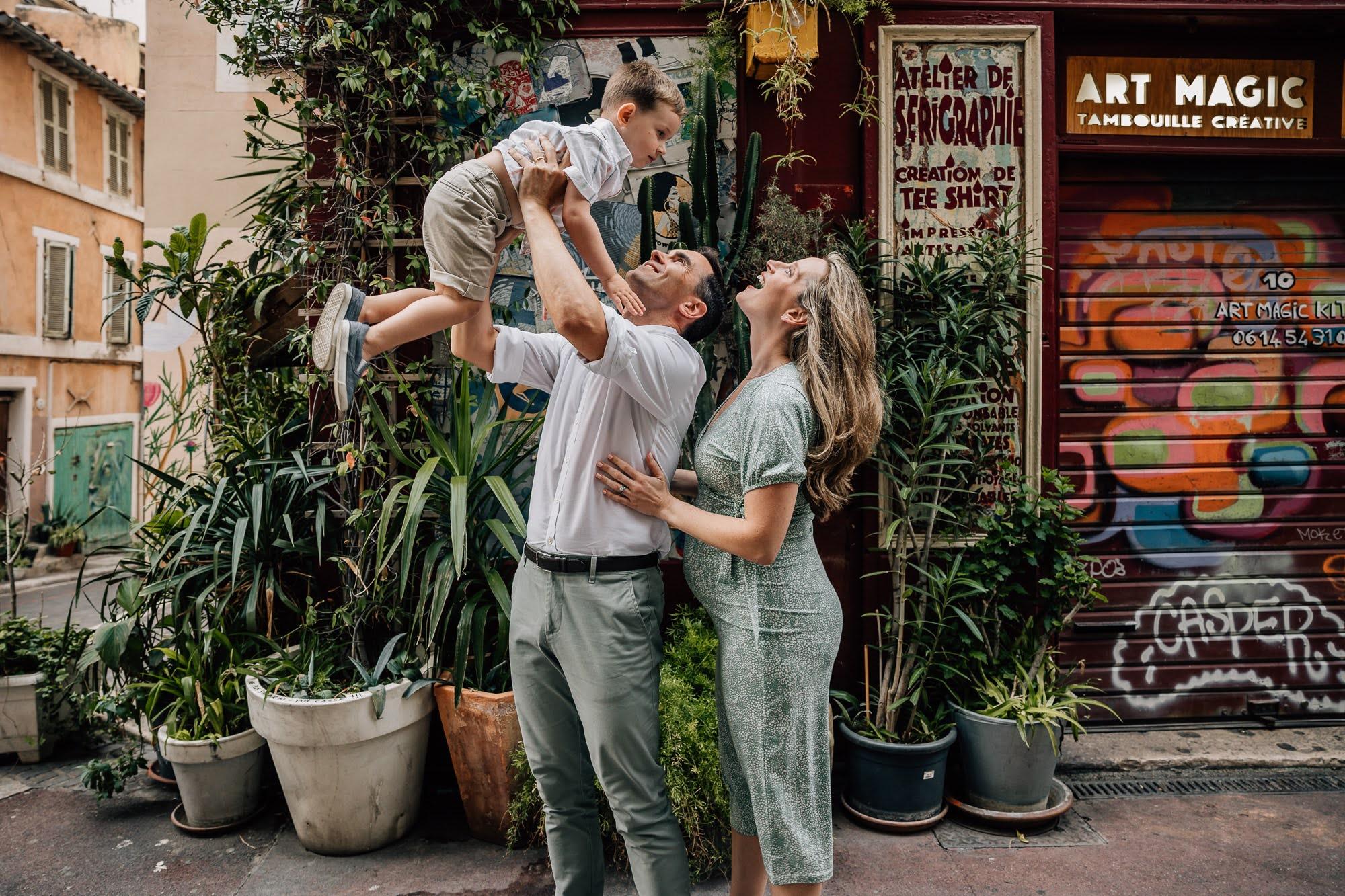 parents qui s'amusent avec leur petit garçon lors d'une séance photo famille dans une ruelle du Panier à Marseille