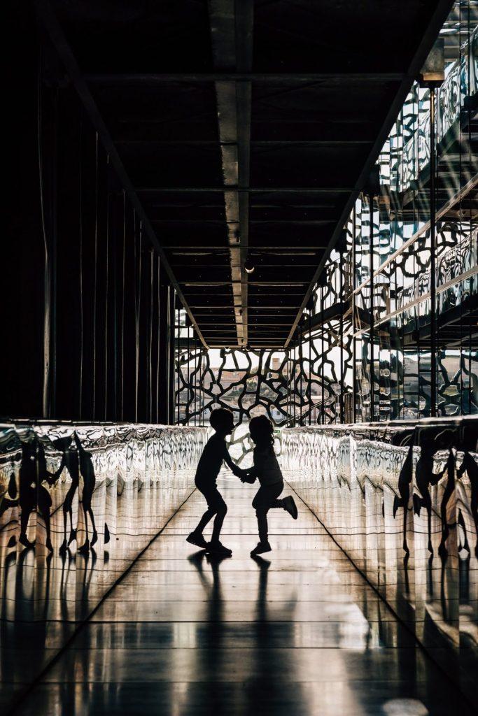 frère et soeur dansent lors d'une séance photo famille au Mucem à Marseille