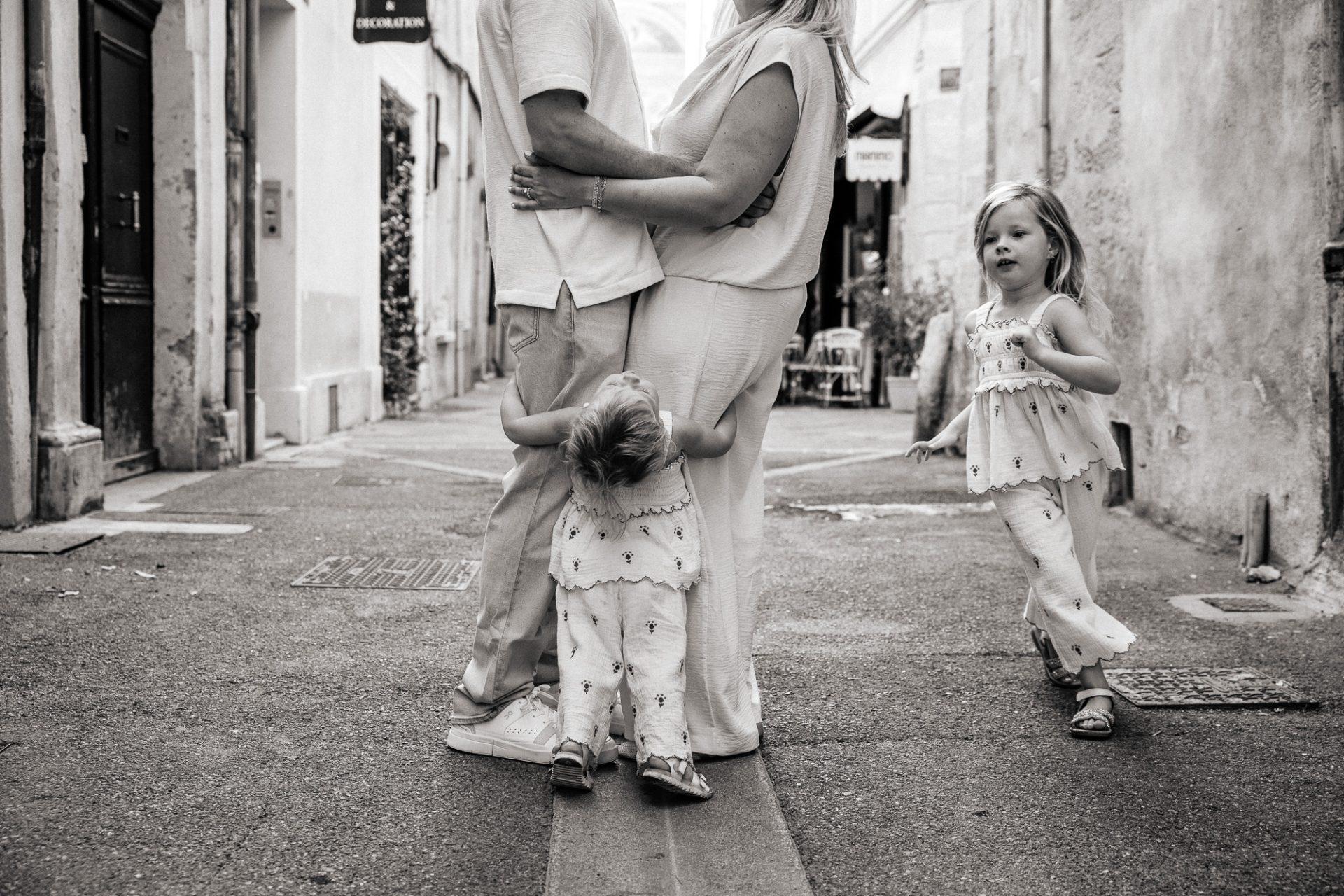 Une famille joue dans les ruelles tranquilles d'Aix-en-Provence lors d'un shooting photo en famille