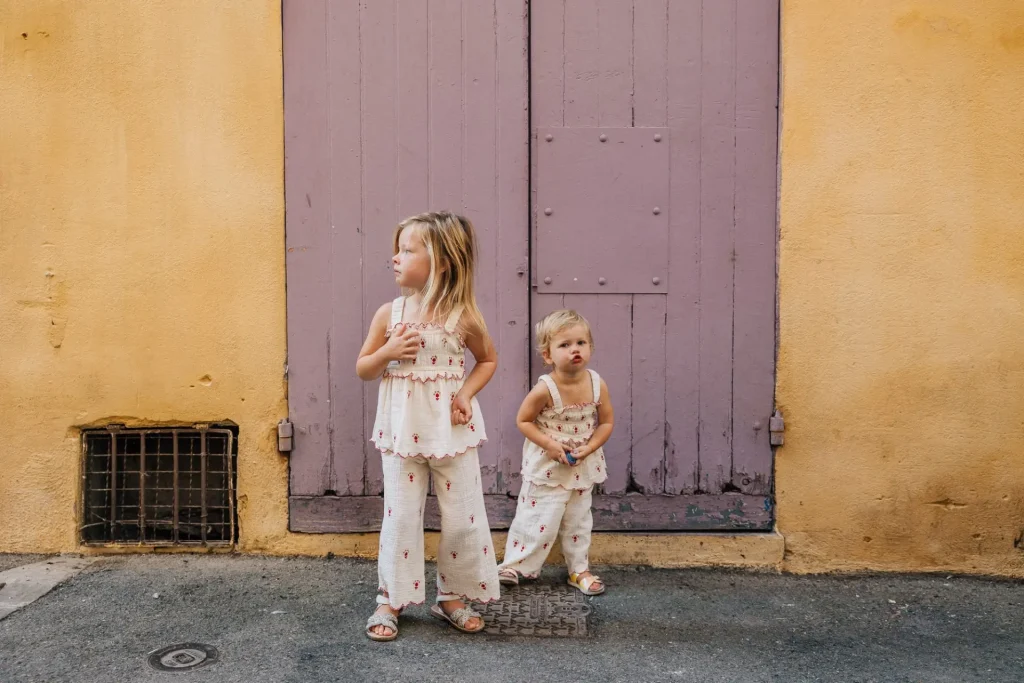 deux petites filles devant une porte colorée à Aix-en-Provence