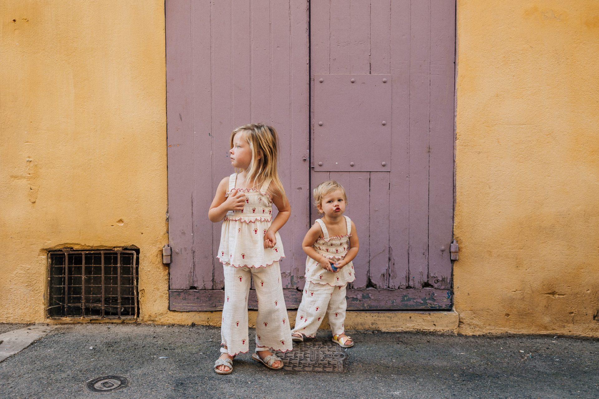 deux soeurs contre un mur coloré lors d'un reportage photo famille à Aix-en-Provence