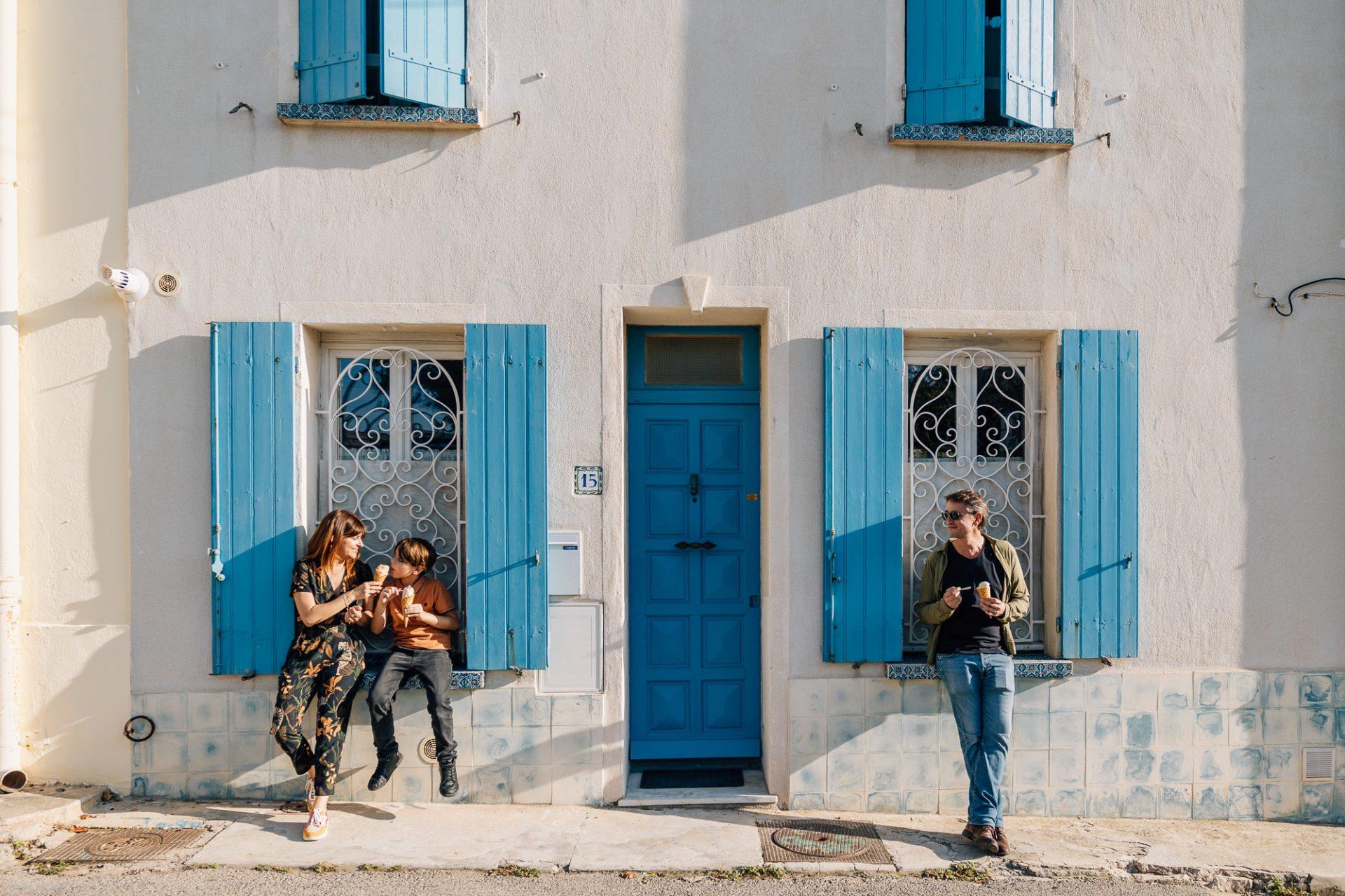 famille mange une glace devant les portes et fenêtres colorées dans les ruelles de Marseille