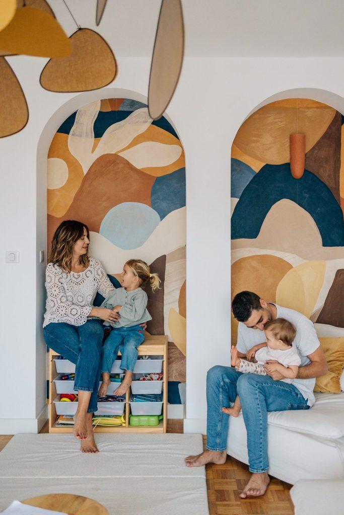 Parents et enfants discutant dans leur salon design et coloré lors d'un shooting photo famille à domicile à Marseille 13009