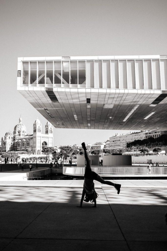 petite fille faisant la roue devant le Mucem à Marseille lors d'un shooting photo à Marseille, photo en noir et blanc