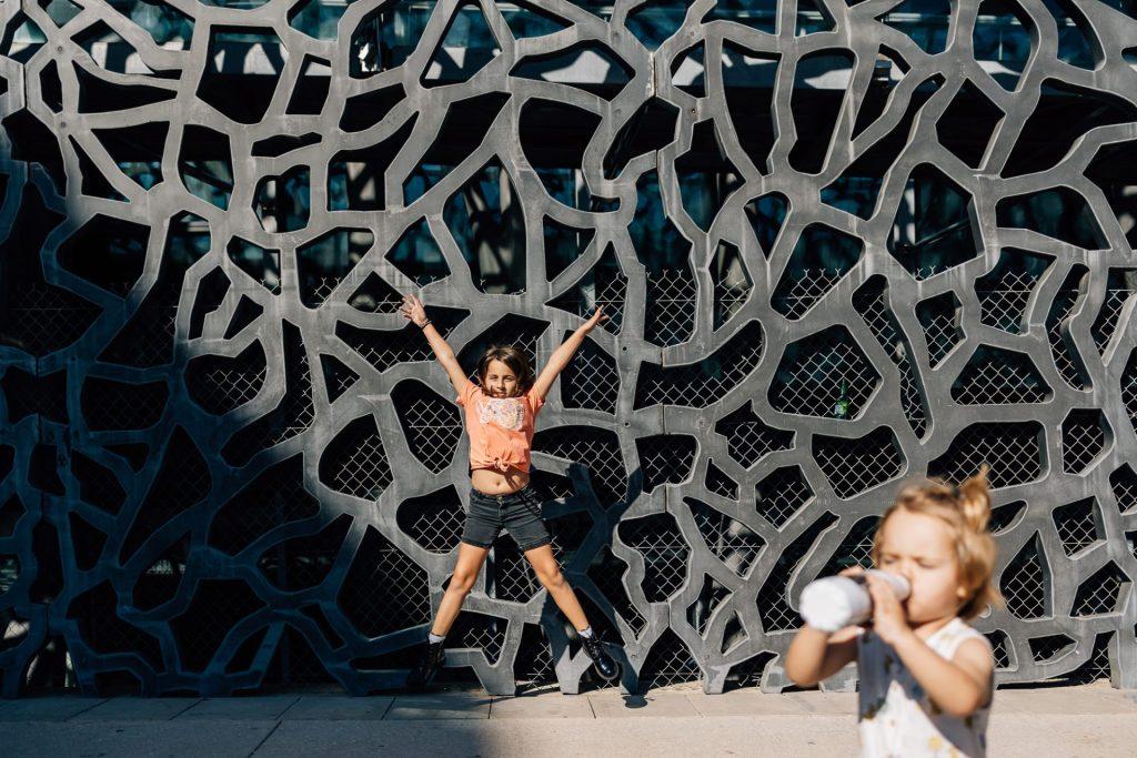 Enfant devant un mur graphique du MUCEM lors d’une séance photo famille urbaine à Marseille