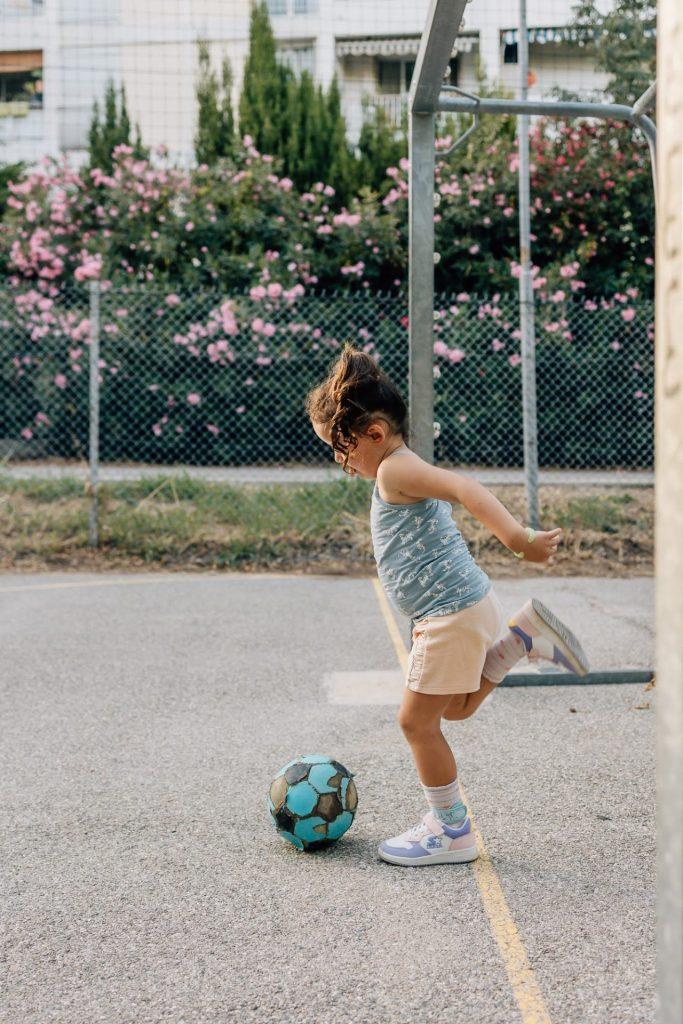 petite fille joue au ballon lors d'une séance photo de famille dans un parc à Marseille 13008