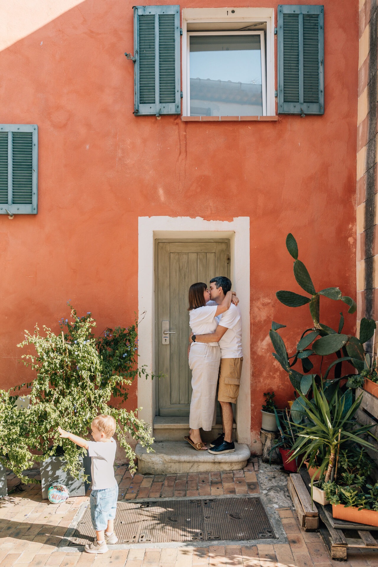 Séance photo couple et famille à Cassis devant une façade orange et volets verts
