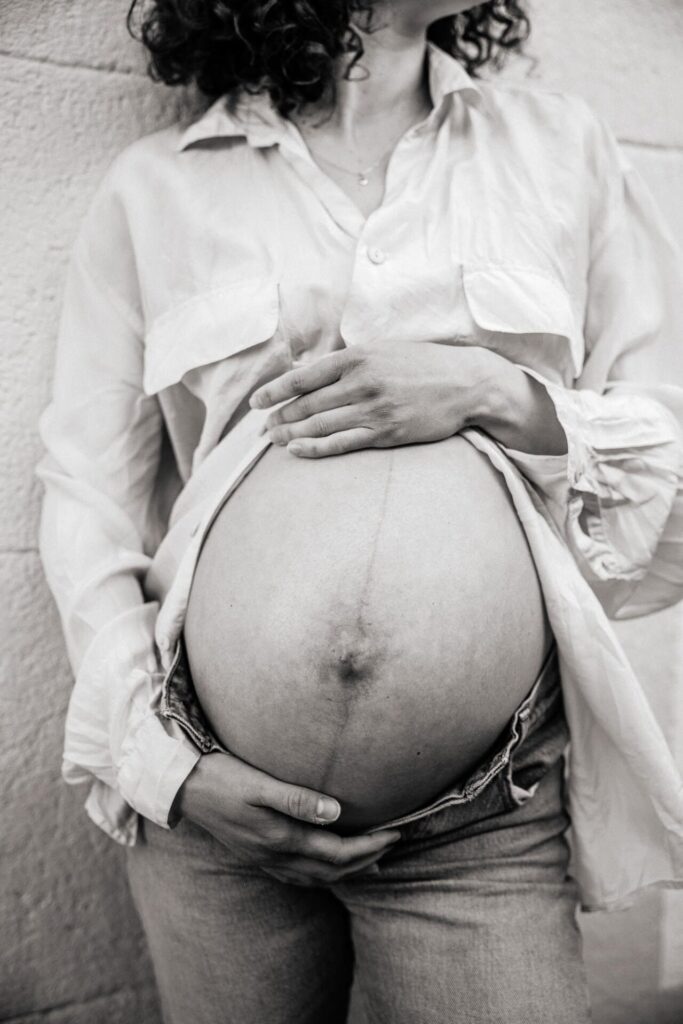style édito, gros plan sur le ventre d'une femme enceinte lors d'une séance grossesse dans les rues de Marseille