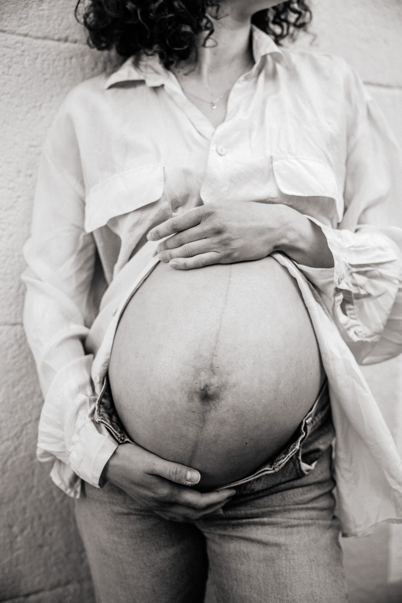 style édito, gros plan sur le ventre d'une femme enceinte lors d'une séance grossesse dans les rues de Marseille