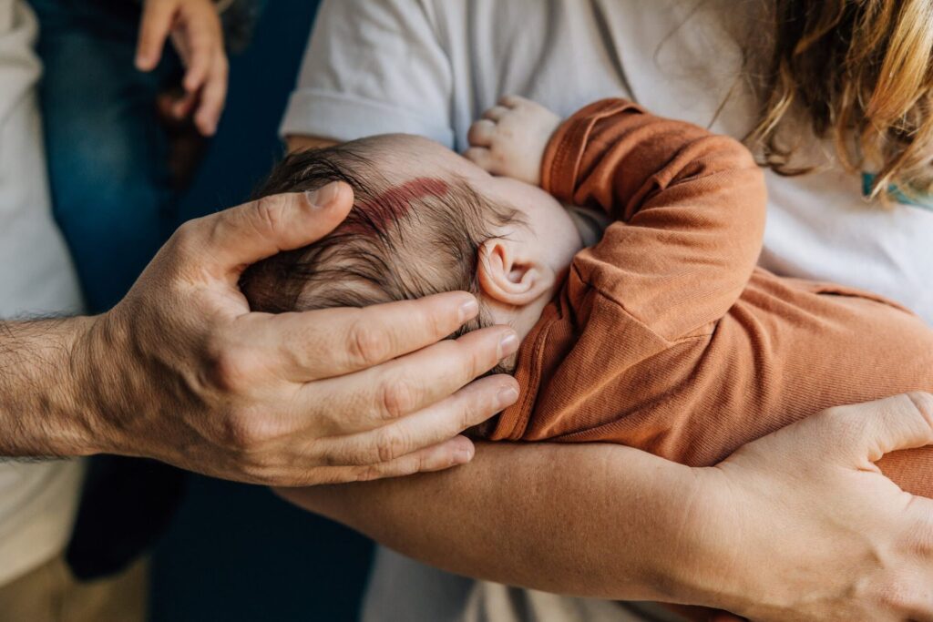 Nouveau-né avec tâche de naissance blotti contre son parent lors d’une séance photo bébé à domicile à Marseille
